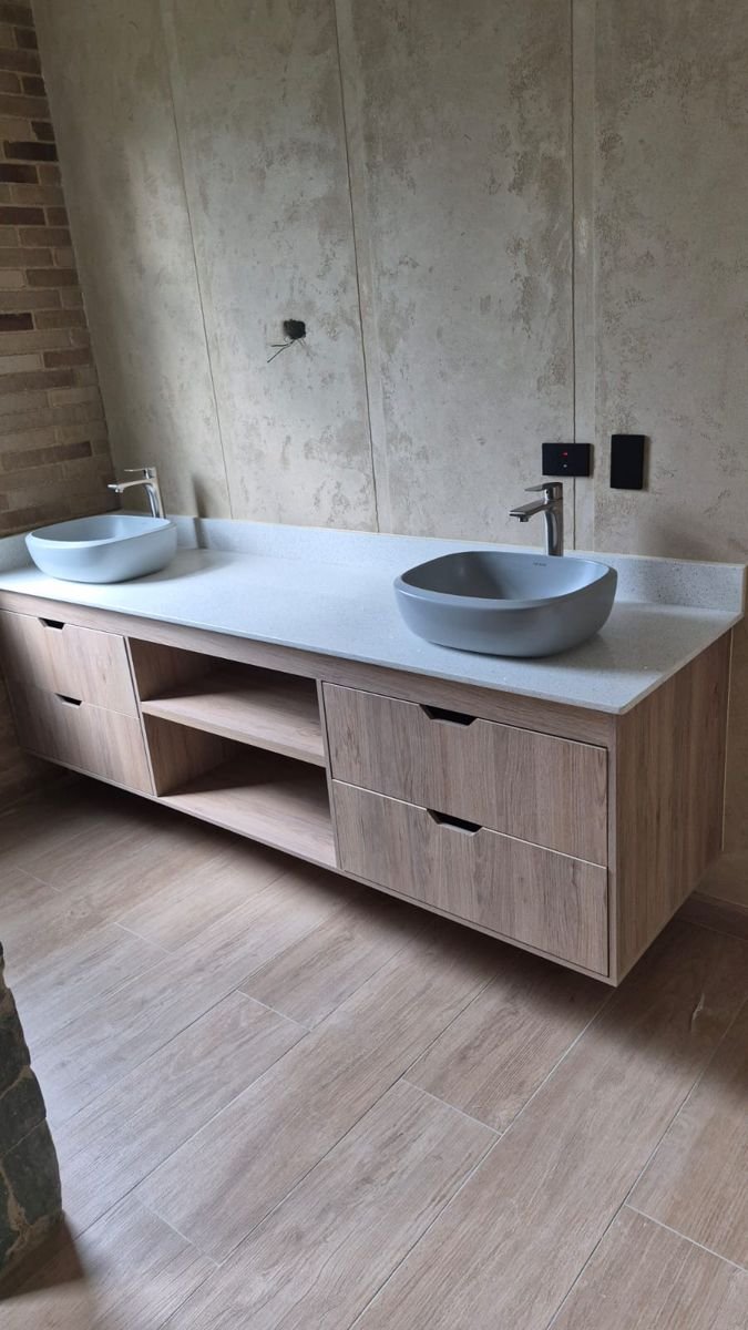 Mueble de baño flotante en madera con lavamanos sobre mesón