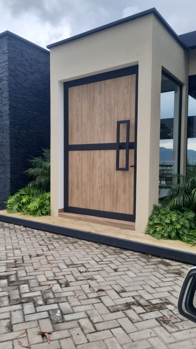 Puerta de entrada en madera con marco negro