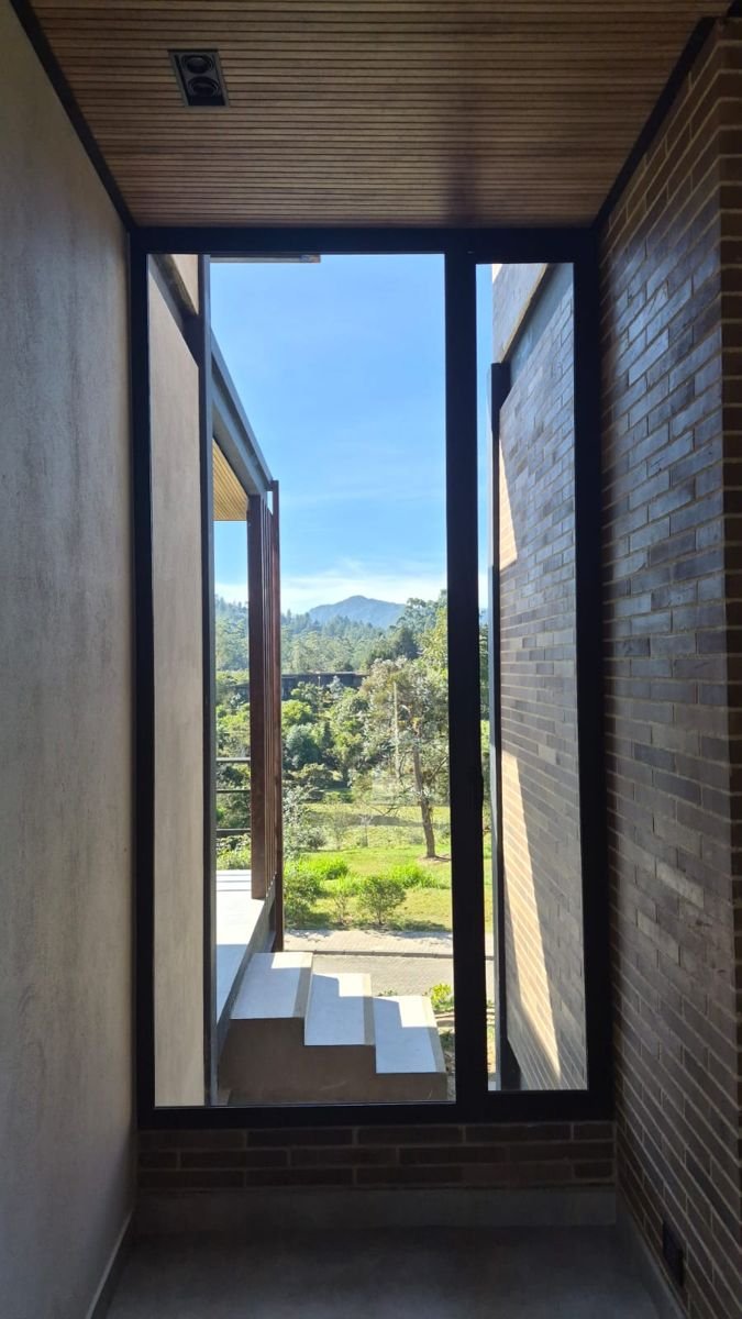 Ventana alta y angosta con marco negro y vista a la montaña