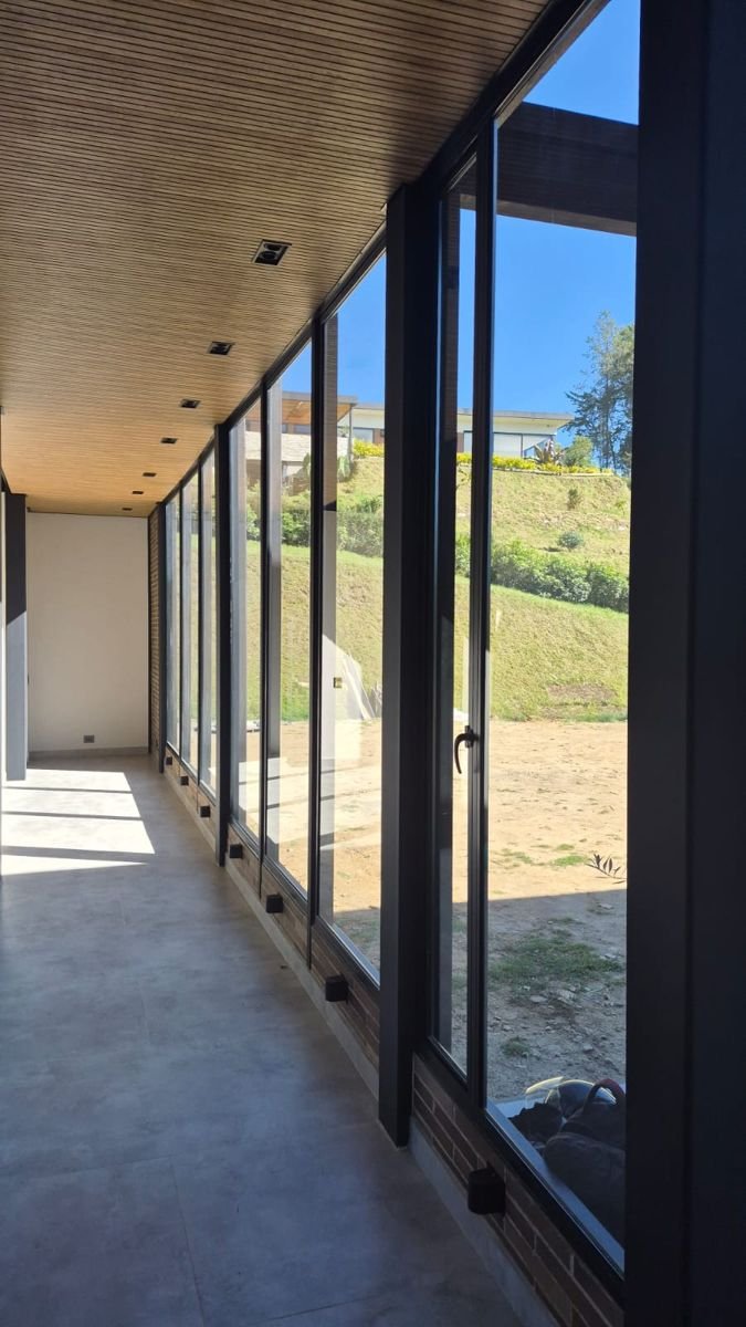 Pasillo con ventanales de piso a techo y marcos negros