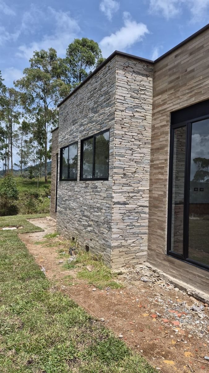 Esquina de vivienda con muro en piedra y ladrillo
