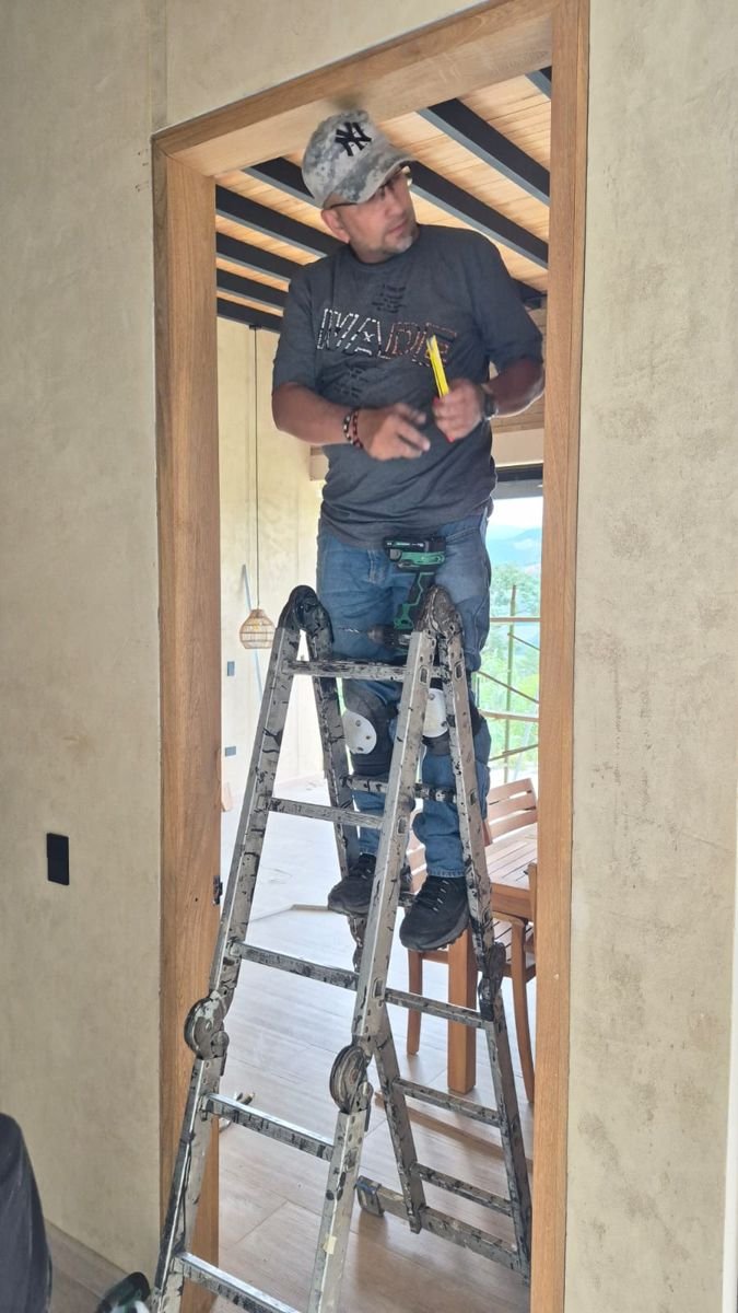 Instalador trabajando en un marco de puerta en madera